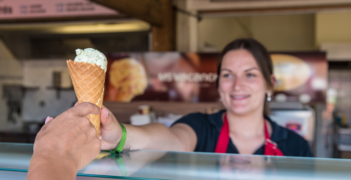 Serveuse tendant une glace artisanale à un client ayant utilisé le paiement cashless au MS Sucré.